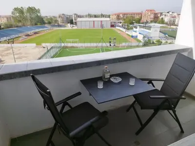a table and two chairs on a balcony with a tennis court at California complex in Sunny Beach