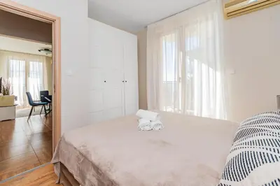a bedroom with a large bed with two towels on it at Royal Bay Apartaments - Sveti Vlas in Sveti Vlas