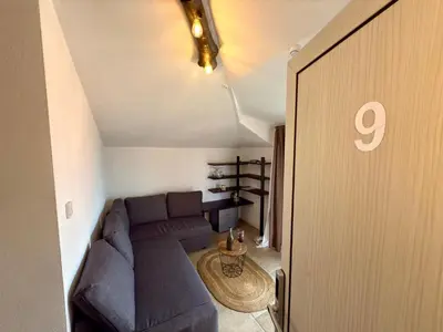 a living room with a blue couch in a attic at Arthotel Oscar I Sozopol in Sozopol