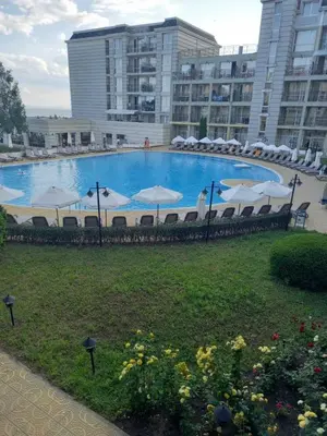 a large swimming pool with umbrellas in a building at Private room Festa Pomorie in Pomorie