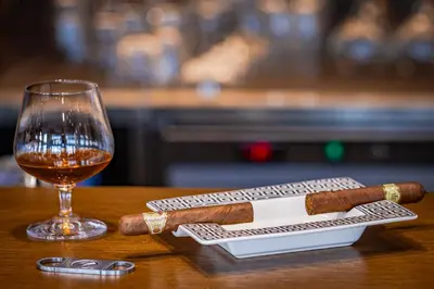 two cigars on a table next to a glass of wine at Casa Deniso - The Home of Chill in Byala