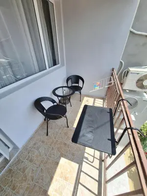 a balcony with chairs and a table and a window at Manolovi Guest House in Obzor