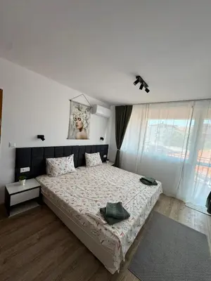 a bedroom with a bed and a picture on the wall at Manolovi Guest House in Obzor