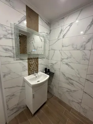 a white bathroom with a sink and a mirror at Manolovi Guest House in Obzor