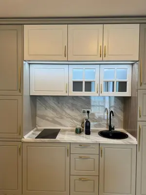 a kitchen with white cabinets and a sink at Santa Maria Luxury Suits in Ravda