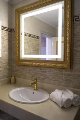a bathroom with a sink with a mirror and a sink at Santa Maria Luxury Suits in Ravda