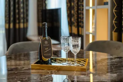 a bottle of wine and two glasses on a table at Santa Maria Luxury Suits in Ravda