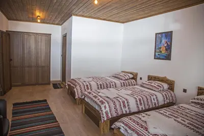 a bedroom with three beds and a wooden ceiling at Chateau Erkech Triple Room in Kozichino