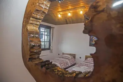 a mirror reflecting two beds in a room at Chateau Erkech Triple Room in Kozichino