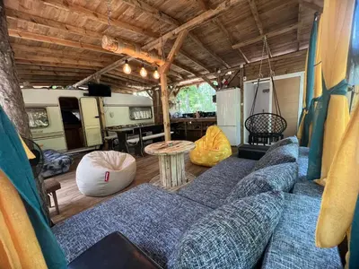 a living room with a blue couch and a table at Каравана градина in Sozopol