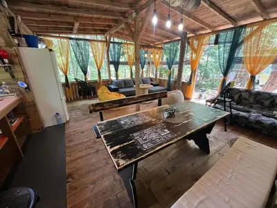 a living room with a table and a couch at Каравана градина in Sozopol