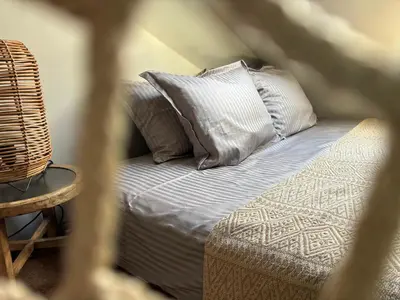 a bed with pillows and a chair in a room at Casa Mint in Sozopol