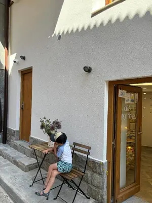 a young child sitting at a table outside of a building at Casa Mint in Sozopol