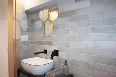 a bathroom with a white sink and a brick wall at Casa Mint in Sozopol