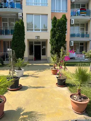 a courtyard with potted plants in front of a building at 'Oasis' Ravda Apartment, Nessebar in Ravda