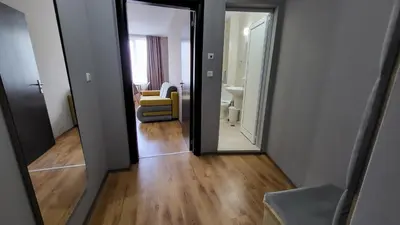 a hallway with a mirror and a living room at Marina Beach Apartments Pomorie in Pomorie