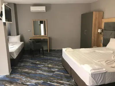 a hotel room with two beds and a desk at Marina Beach Apartments Pomorie in Pomorie