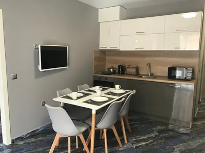 a kitchen with a table and chairs in a kitchen at Marina Beach Apartments Pomorie in Pomorie