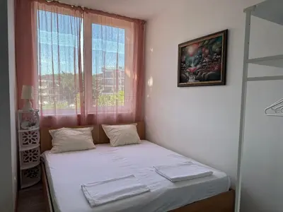 a small bedroom with a bed with a window at Оазис in Ravda