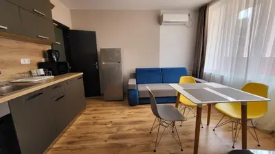 a kitchen with a table and chairs in a room at Marina Bay Apartmant in Pomorie