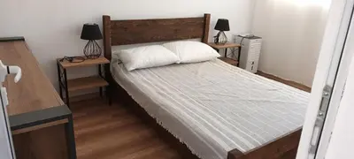 a bedroom with a large bed with two night stands at Стаи за гости Пансионът на Роуз Вълшебната ми Кръстница in Chernomorets