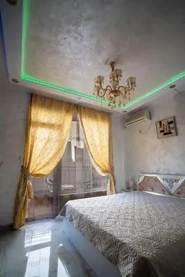 a bedroom with a bed with a chandelier and a window at AR Luxury Apartments Ravda in Ravda