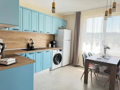 a kitchen with blue cabinets and a table with a dining room at Boho and More in Sozopol