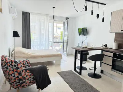 a kitchen and living room with a table and a desk at Deco Fusion in Sozopol