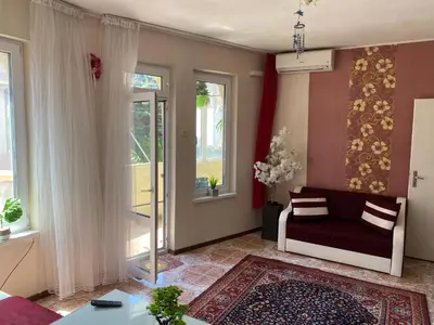 a living room with a couch and two windows at Centrum in Burgas City
