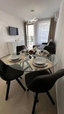 a dining table with chairs and plates on it in a living room at Polar Star 106 B in Saint Vlas in Sveti Vlas