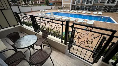 a balcony with a table and chairs and a pool at Polar Star 106 B in Saint Vlas in Sveti Vlas