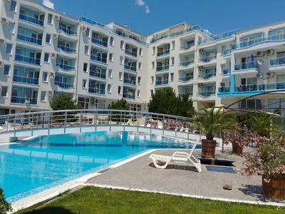 a large apartment building with a large swimming pool at Studio 41 in Ravda