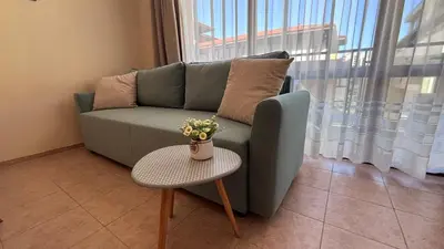 a living room with a green couch and a table at One bedroom Apartment in Sunny Beach