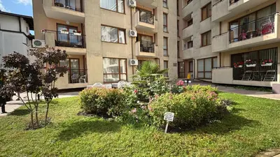 an apartment building with a sign in the middle of a yard at One bedroom Apartment in Sunny Beach