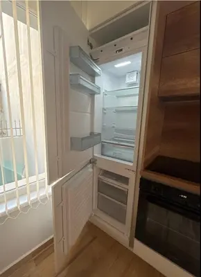 a kitchen with an empty refrigerator and a window at Goldy central beach apartment with private garden Burgas in Burgas City