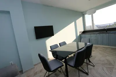 a dining room with a table and chairs and a tv at Panoramic Penthouse Apartment in Varna City