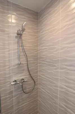 a shower with a shower head in a bathroom at Panoramic Penthouse Apartment in Varna City