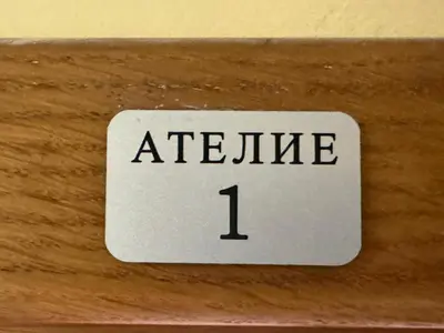 a white sign with the word ateline on a wooden door at KAYA Atelie 1 Sunny Beach in Sunny Beach