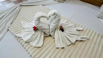 two swans are made out of towels on a bed at KAYA Atelie 1 Sunny Beach in Sunny Beach