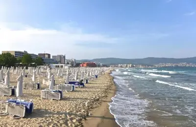 a beach with lounge chairs and the ocean at KAYA Atelie 1 Sunny Beach in Sunny Beach