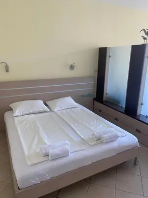 a bedroom with a bed with white sheets and towels at Central Beach Apartament in Sunny Beach