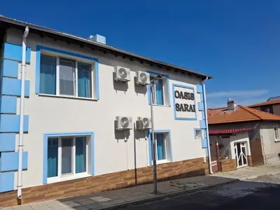 a white building with a sign that reads guest center at Вила Оазис Сарай - Царево in Tsarevo