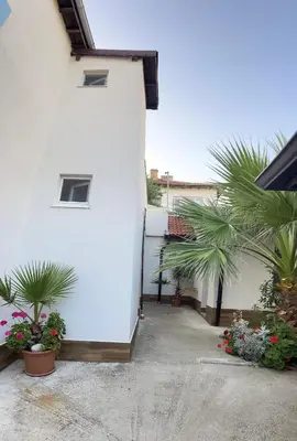 a white building with some plants in a courtyard at Вила Оазис Сарай - Царево in Tsarevo