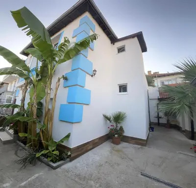a white building with blue blocks on it at Вила Оазис Сарай - Царево in Tsarevo