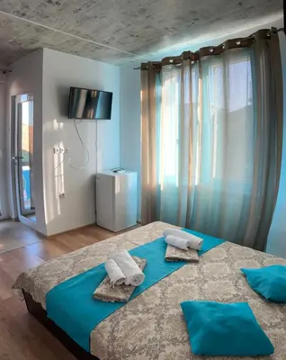 a bedroom with a large bed with towels on it at Вила Оазис Сарай - Царево in Tsarevo