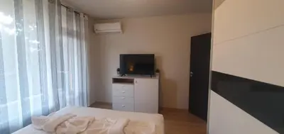 a bedroom with a bed and a television on a dresser at Central Beach Ravda Apartments in Ravda