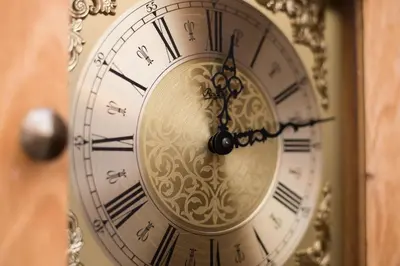 a gold clock with roman numerals on a wall at Beehive Hotel and CoWorking in Varna City