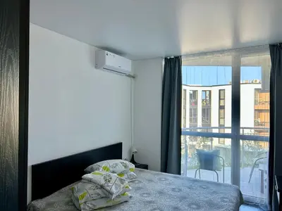 a bedroom with a bed and a large window at Atlantis Resort & 4 swimming pools & Spa & Апартамент in Burgas City