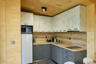a kitchen with gray cabinets and a white refrigerator at Holiday Village Smokinia in Sozopol