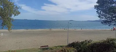 a beach with a street light and a bench at Apartament Lazur 13 in Burgas City